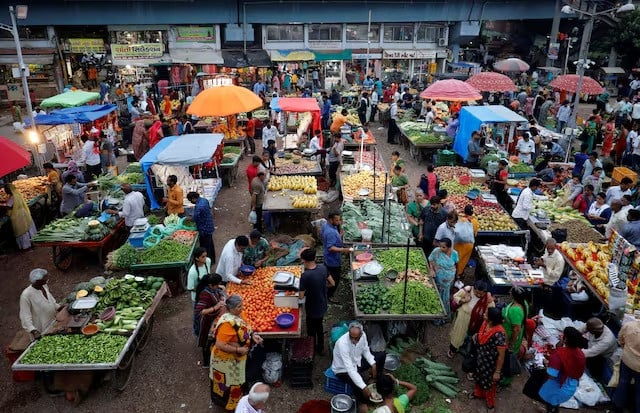 customers buy fruits and vegetables at an open air evening market in ahmedabad india photo reuters